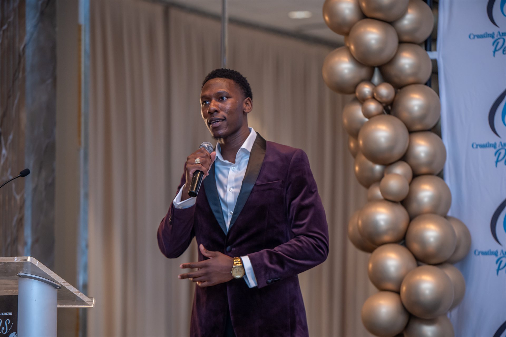 Delasi speaking on stage in Maryland, USA